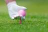 Ladies Golf Hand Placing Pink Tee And Ball Into Ground. Stock Photos - 31851113